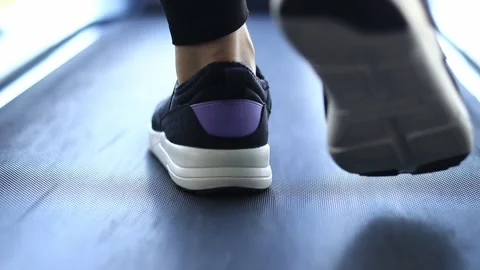 Back view of legs in sneakers walking on the treadmill in the fitness room Stock Footage 283389130