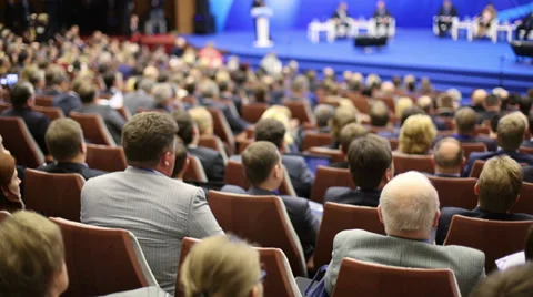 Back view listeners sitting in large a hall with blue stage Video stock 35238753