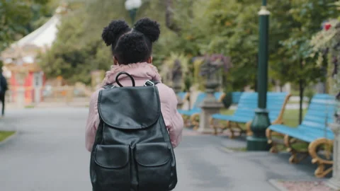 Back view little afro american girl african kid black child with backpack runs Video stock 163337702