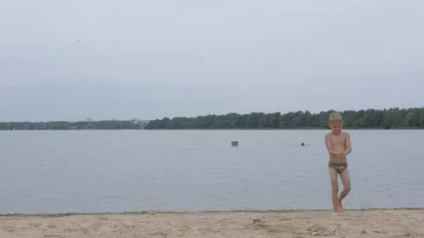 Back view of a little boy at beach walking on the coastline Stock-Footage 158332229