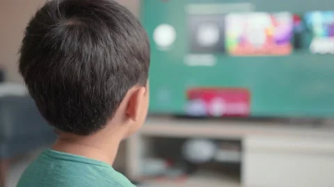 Back view of little boy choosing cartoons using smart TV. New generation. Stock Footage 183840048