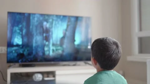 Back view of little boy watching movie on TV at home Stock Footage 187050427