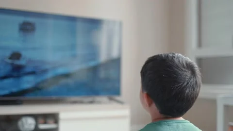Back view of little boy watching movie on TV at home Stock Footage 189352095
