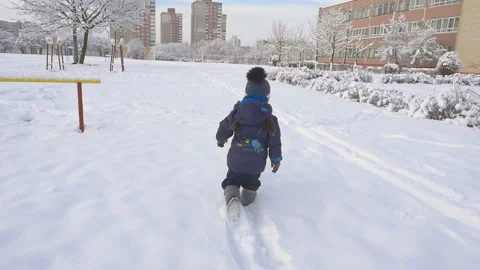 Back view of little child running and playing with snow in winter slow motion Video stock 96430172