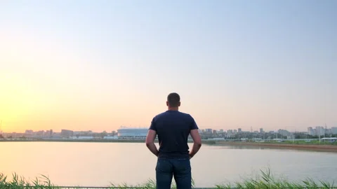Back view of lonely caucasian man standing and enjoying view looking at lake on  Stock Footage 149941513