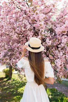 Back View of the Long Haired Drunette Girl in Straw Hat And White Dress Standing Stock Photos