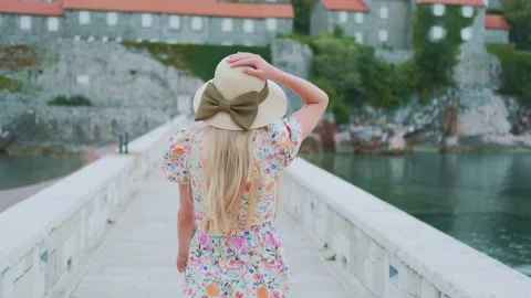 Back view of long haired woman in hat with ribbon bow and floral dress Stock Footage 167688948