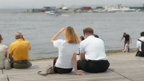 Back view of a loving elderly couple sitting on a park bench watching the s.. 動画素材 344466708