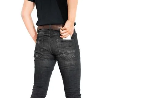 Back view of lower body of man putting smart phone into pocket on isolated wh 写真素材