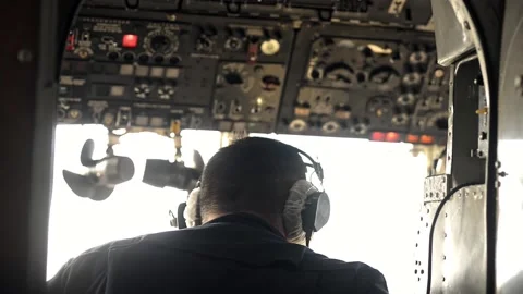 Back view of male pilot working and sitting in cockpit of airplane during flight Stock Footage 157229404