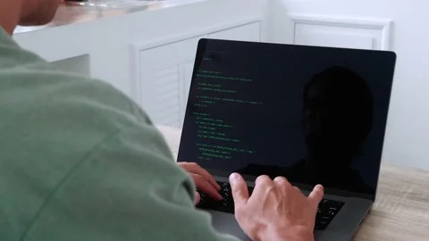 Back view of male programmer developer freelancer writing green code at a laptop Stock Footage 200891961