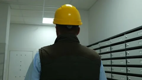 Back view of male worker in yellow helmet walking indoor in residential building Stock Footage 201968469