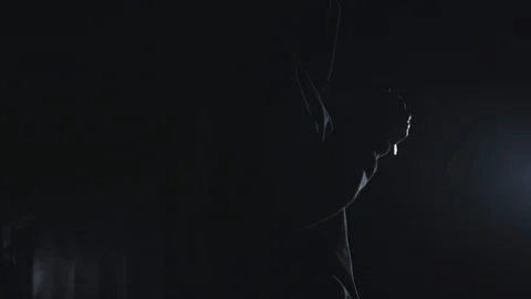 Back view of a man in balaclava with flashlight showing a sign to follow him to Video stock 105267716