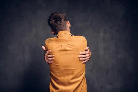 Back view of man clenched hands on dark background Stock Photos