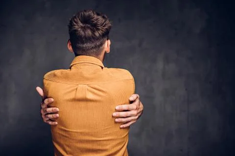 Back view of man clenched hands on dark background Stock Photos