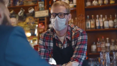 Back view of man client talking to bartender wearing safety mask and gloves Stock Footage 146911215