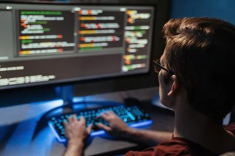 Back view of man coding for cyber security, programming and working from home at Stock Photos