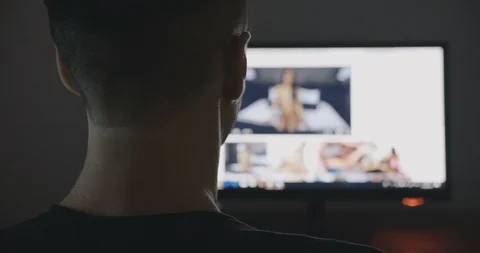 Back view of man communicates through porn chat virtual sex at night Stock Footage 95496873