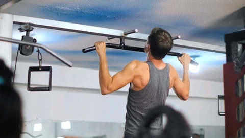 Back view of a man with develop back muscles doing pull up exercise in the gym . Stock Footage 126635939