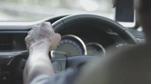 Back view of a man driving Car on asphalt road. Driver holding steering wheel Stock-Footage 336266307