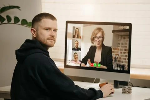 A back view of a man during a video call with his colleagues Stock Photos