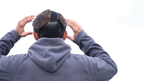 Back view of man getting experience using VR-headset glasses of virtual reality Stock Footage 84217595