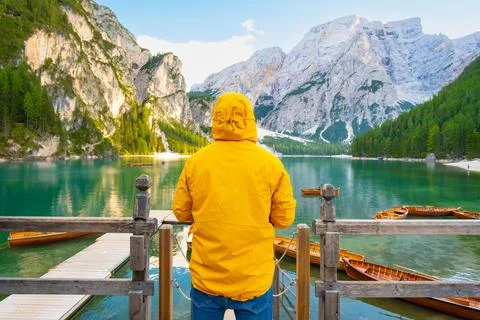 Back view of the man having fun on lake Braies with wooden boats in the Stock Photos
