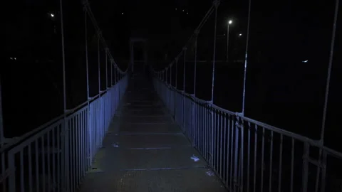 Back view of Man with Headlamp Riding Bicycle On Small pedestrian metal bridge A 스톡 동영상 147269252