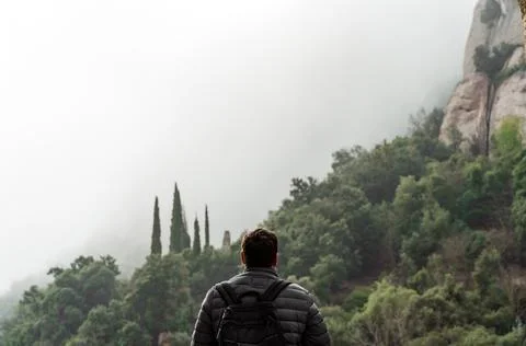 Back view of man on hiking trail. Backpacker traveling. Stock Photos