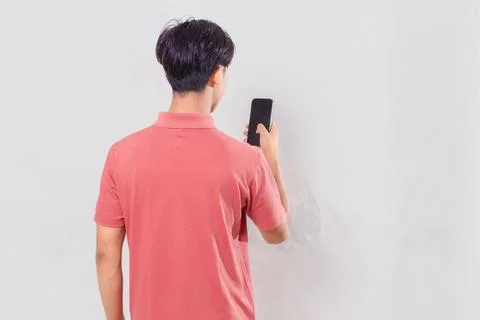 Back view of a man holding and using a mobile phone, isolated on a white ba.. Stock Photos