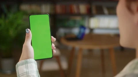 Back View of Man Holding Chroma Key Green Screen Smartphone Watching Content Stock Footage 205801681