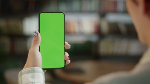 Back View of Man Holding Chroma Key Green Screen Smartphone Watching Content Stock Footage 205801885