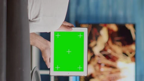 Back view of man holding digital tablet with green screen watching social media Stock Footage 178452526