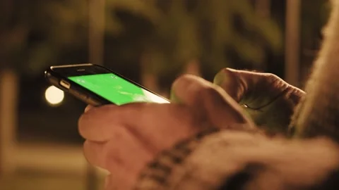 Back view of man holding smart phone with green screen Stock Footage 155799105