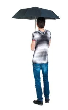 Back view of man in jeans under an umbrella Foto stock