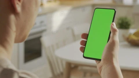 Back View of Man at Kitchen Room Sitting on a Chair Using Phone With Green Mock Stock Footage 205572088