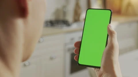 Back View of Man at Kitchen Room Sitting on a Chair Using Phone With Green Mock Stock Footage 205575225