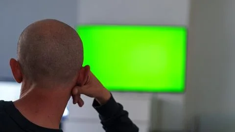 Back view of man looking at green screen monitor Stock Photos