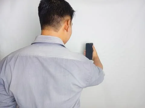 Back view of a man looking to the mobile phone that he hold Stock Photos