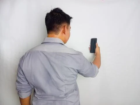 Back view of a man looking to the mobile phone that he hold Stock Photos