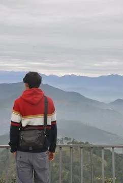 Back view of a man looking to mountains while standing outdoors  Stock Photos