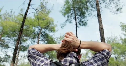 Back view of man making hair bun outdoors. Stock Footage 151863048