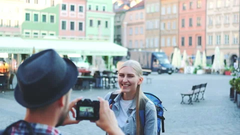 Back view of man making photos of female tourist on the view of city market Video stock 142978279