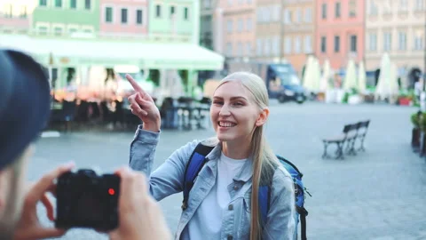 Back view of man making photos of woman tourist on the view of city market Stock Footage 143010305