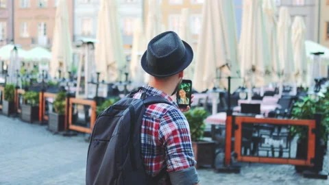 Back view of man making video call on smartphone with female tourist from other Video stock 142946572