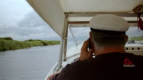 Back view of man on motorboat sailing fast on shiny water of lake in bright Stock Footage 253556849