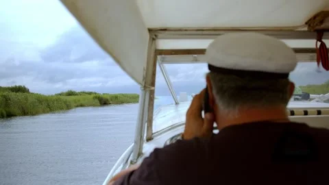 Back view of man on motorboat sailing fast on shiny water of lake in bright Stock Footage 253852331