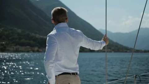Back view of man or groom stands on the yacht on sunny day sailboat Stock Footage 92369679