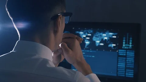 Back view of man programmer in glasses and white shirt working at computer in Stock Footage 106310311