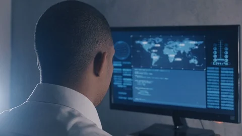 Back view of man programmer in white shirt working at computer in the data Stock Footage 108069162